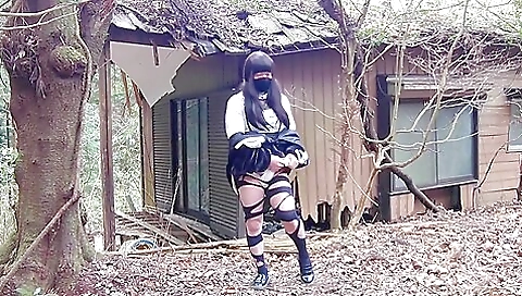 Brunette in black stockings is masturbating outdoors